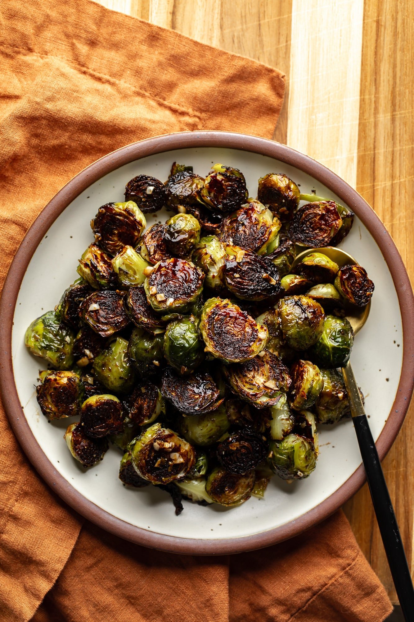 A bowl of shoots of Brussels roasted with slightly carbonized edges.