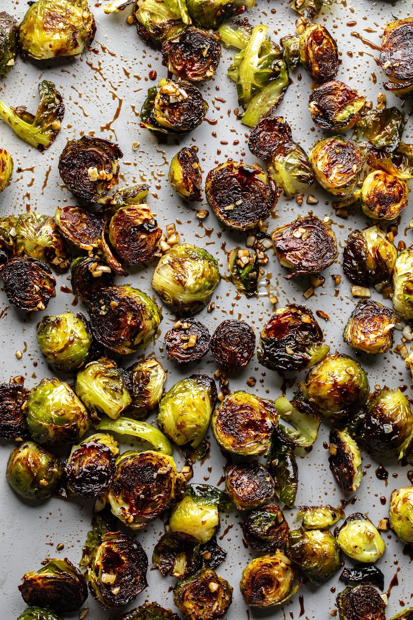 Brussels shoots roasted with slightly carbonized edges on a plate.