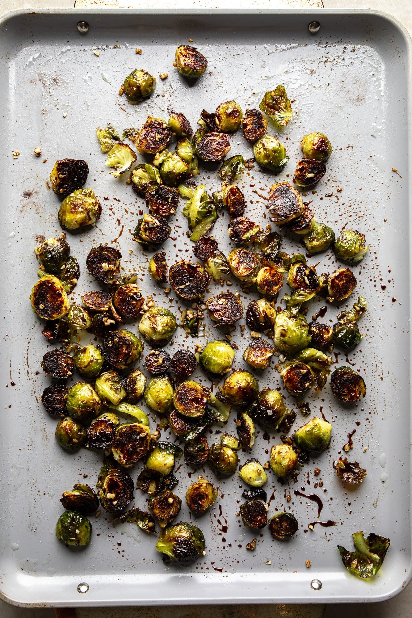 Brussels shoots roasted with slightly carbonized edges on a plate.